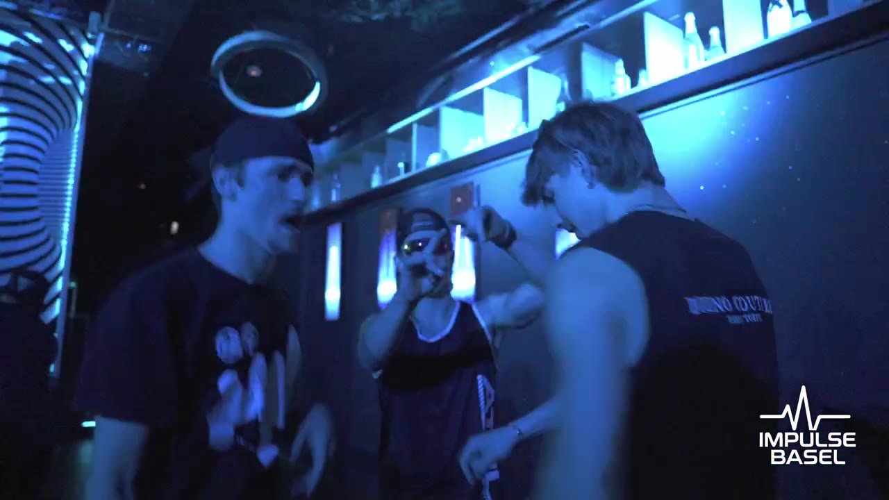 Still from the Impulse Basel aftermovie: people at a club bar in blue light